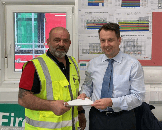 a person proudly holding a certificate labeled "Contractor of the Month October 2022."