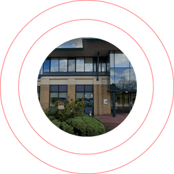 Modern commercial building entrance framed by a bold red circular design
